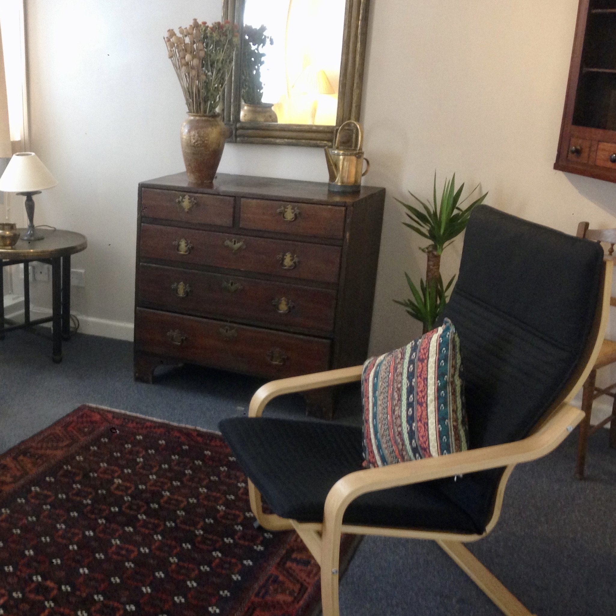 Therapy room with chair, chest of drawers and a mirror at The Practice Rooms in Oxford