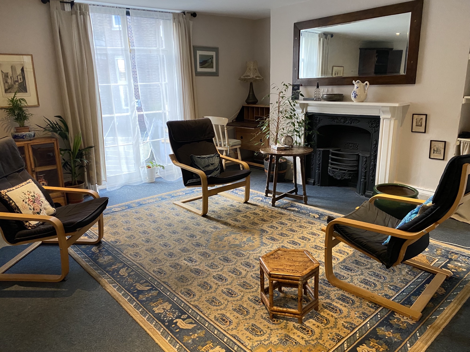 Spacious therapy room with 3 chairs and a large fireplace at The Practice Rooms in Exeter