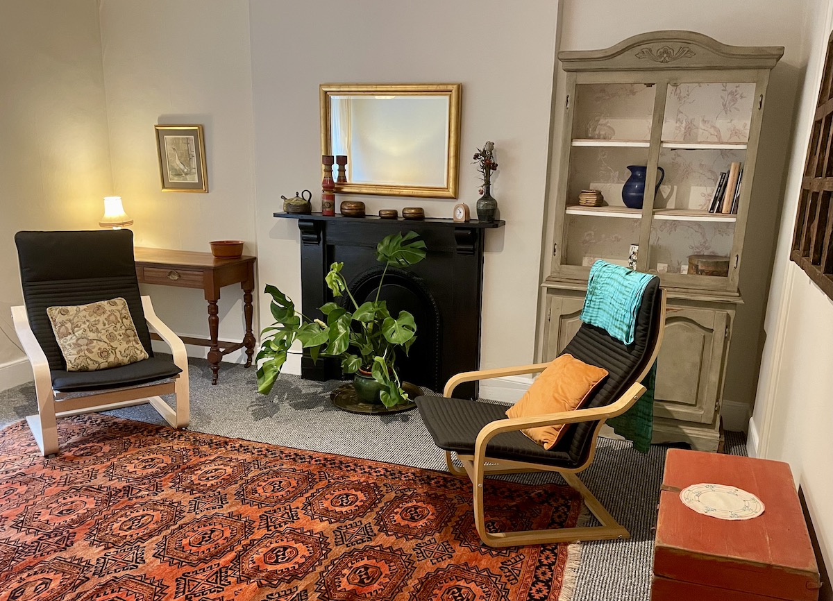 Therapy room with two chairs, a fireplace, and plants